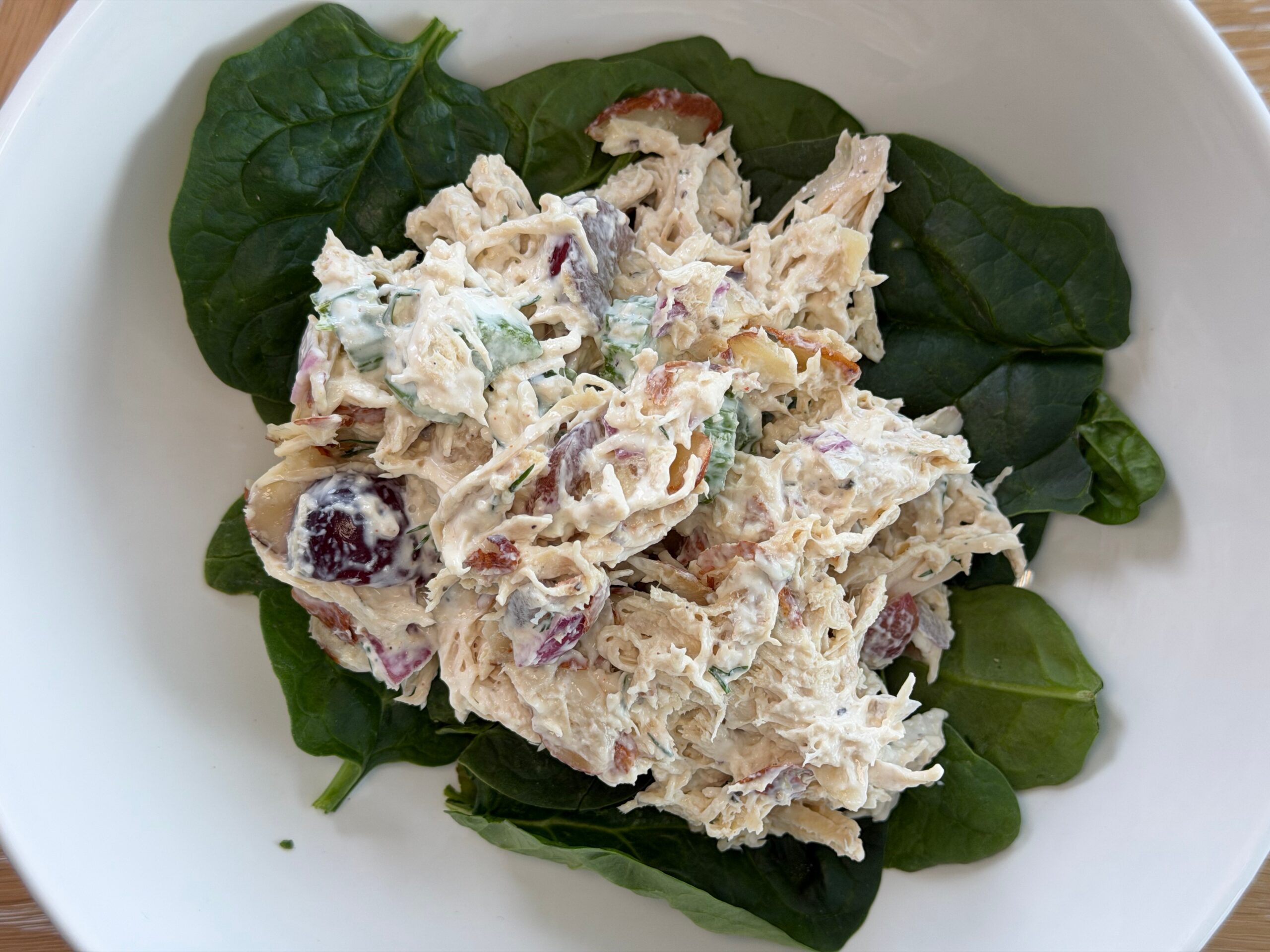Chicken salad with grapes and toasted almonds served over fresh spinach