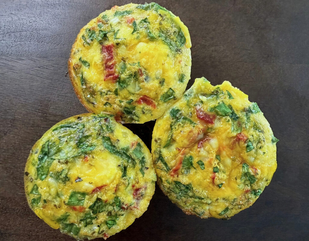 Three roasted red pepper cottage cheese egg bites with spinach and feta